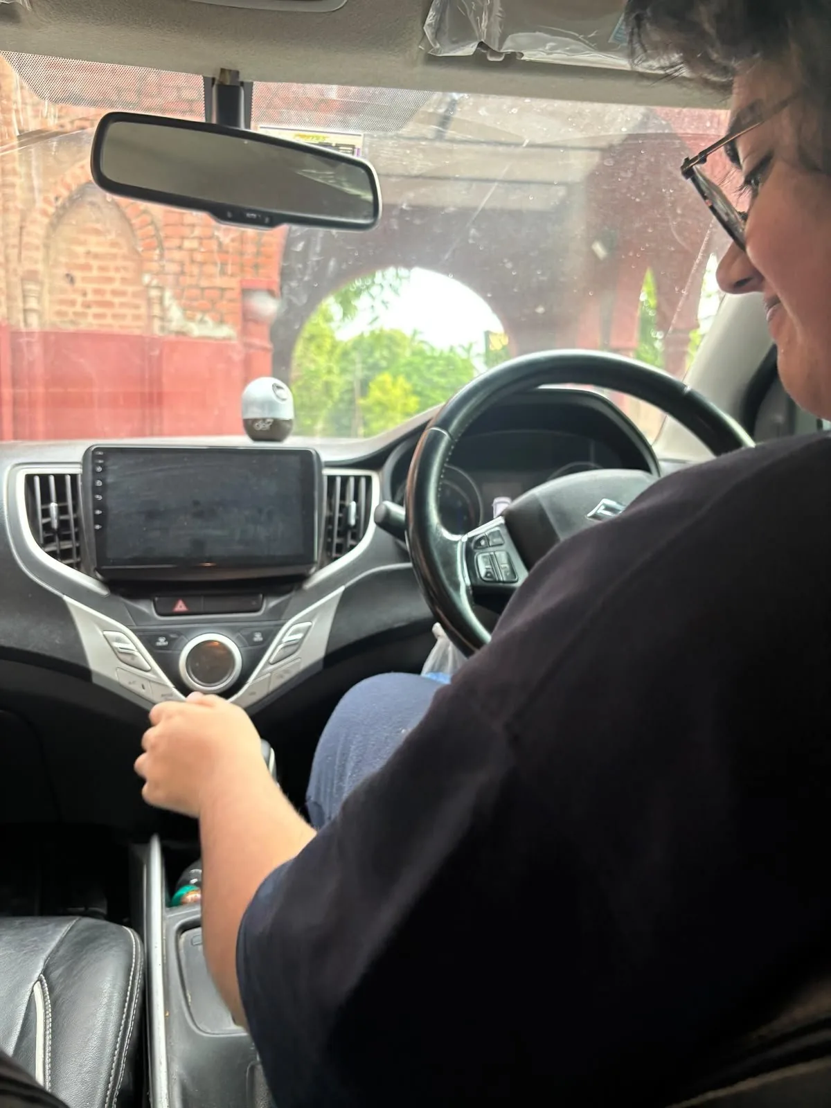 behind the wheel, archway and brick in the windshield