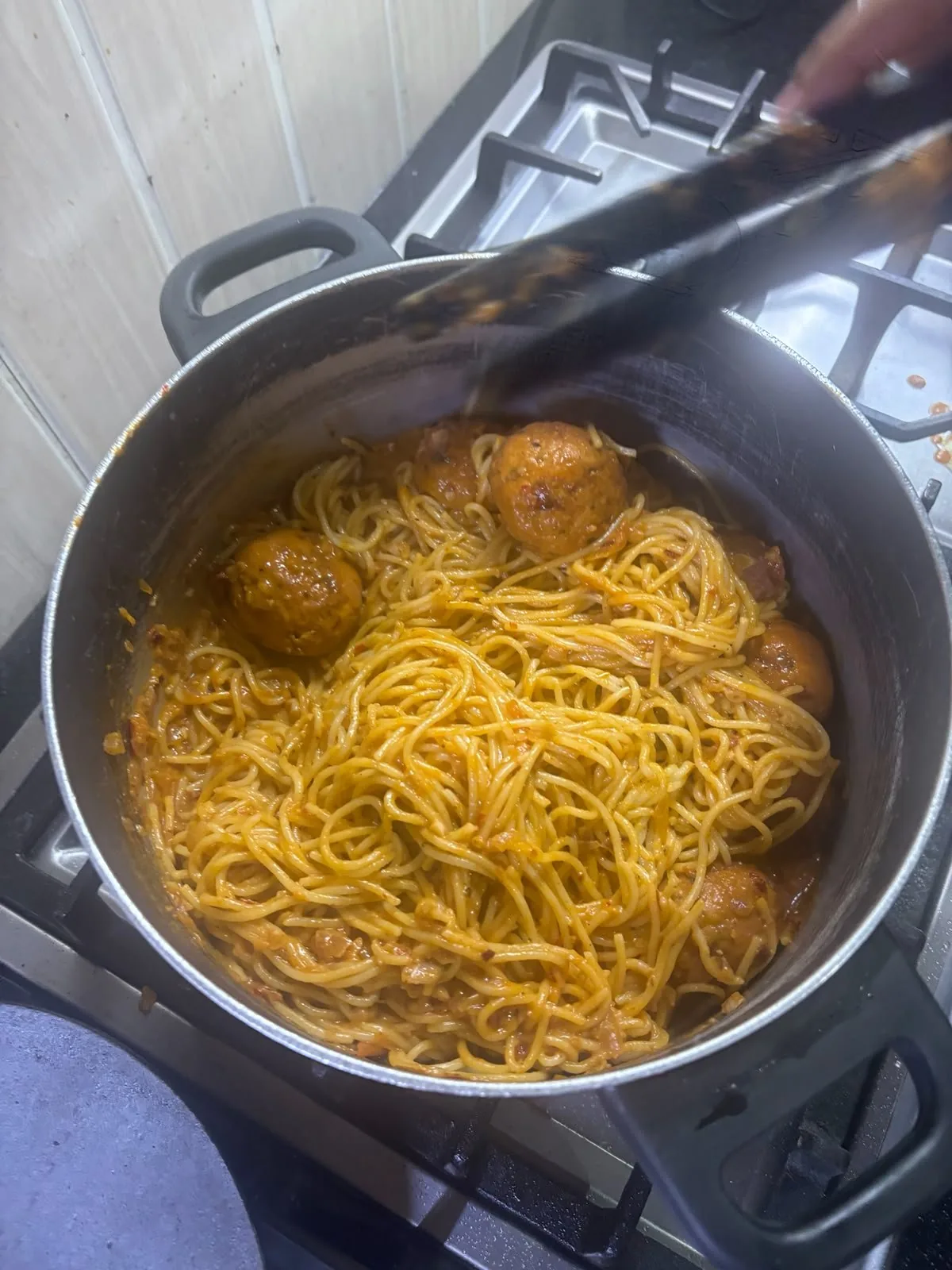 a pot of spaghetti with sauce and meatballs